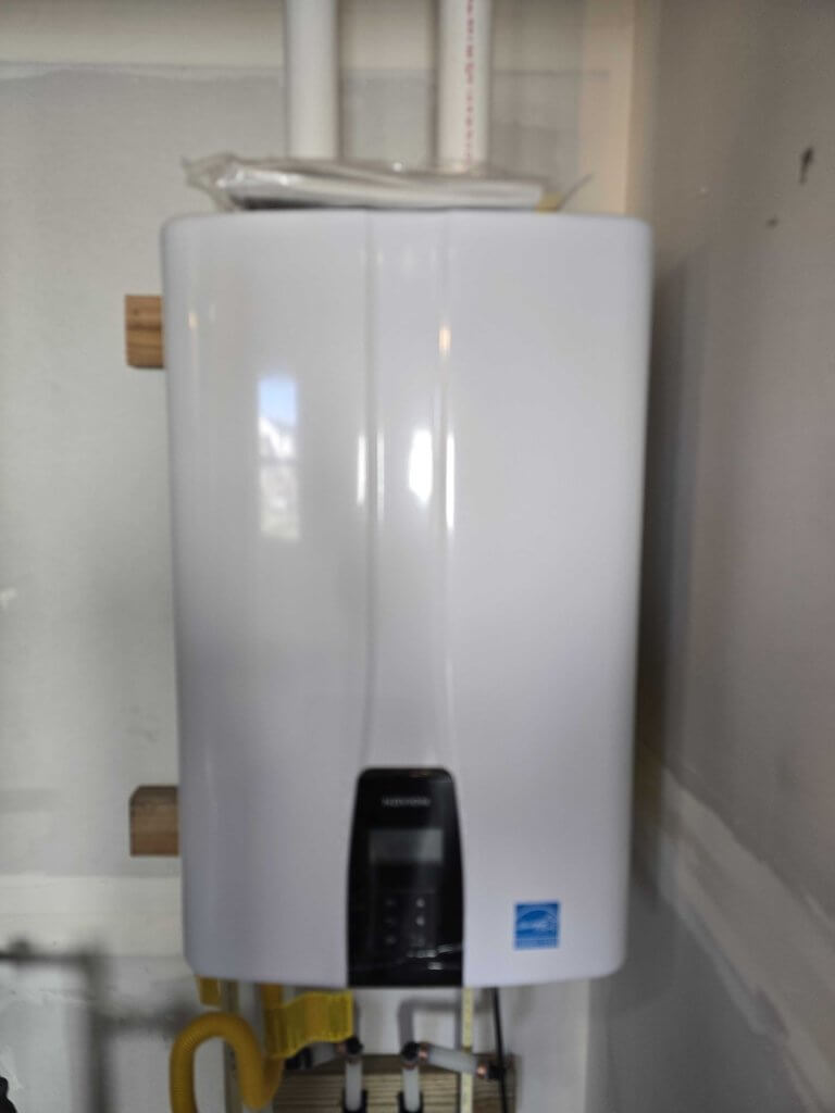 Wall-mounted gas tankless water heater providing on-demand hot water without a storage tank, installed in a residential home.